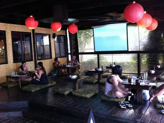 Diners seated on floor cushions at Banzai Sushi with red lanterns