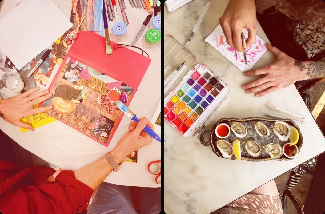 Two photos from above. Left: Joe gluing a collage of a jack-o'-lantern, a black cat and a wheat field onto red paper, surrounded by markers and glue jars. Right: Joe sketching in pink watercolor at a marble cafe table next to a paint palette and a plate of oysters.